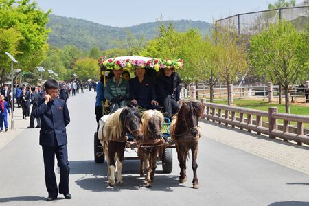 Pyongyang, North Korea - May 1, 2019: Local people  riding a cart on the Pyongyang streetのeditorial素材