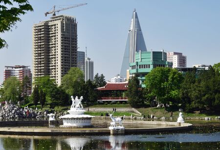 Pyongyang, North Korea - May 1, 2019: View of an Pyongyang park with a pond and a fountain with...