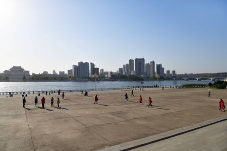 Pyongyang, North Korea - May 1, 2019: People on the embankment near the Juche tower. Skyline and Taedong river on backgroundのeditorial素材