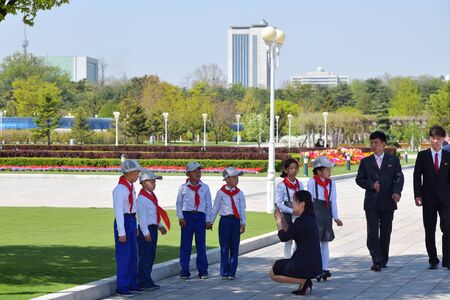 Pyongyang, North Korea - May 2, 2019: The counselor photographs a squad of pioneers in the territory Kumsusan Memorial Palace of the Sun, Mausoleumof Kim Il Sung and Kim Jong Ilのeditorial素材