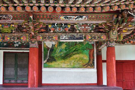 Myohan, North Korea - April 30, 2019: A typical example of wooden medieval architecture, wood carving and colored painting of the era of Koryo. Beams with bright colorful painting under roof. Buddhist monastery bohenのeditorial素材