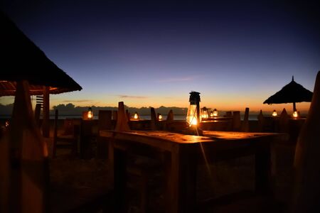 Romantic night on Indian ocean shore. Beach cafe and lighting lanterns, Kendwa beach, Zanzibar,...