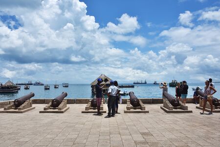 Stone Town Zanzibar, Tanzania - October 7, 2019: Tourists on the waterfront of Stone Town with old...