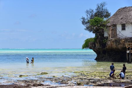 Pingwe, Zanzibar - October 6, 2019: Local children play nearby The Rock restaurant. It is world-famous restaurant known for its extraordinary location in ocean and landmark of Zanzibar islandのeditorial素材