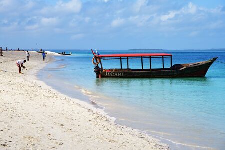 Kendwa, Zanzibar - October 6, 2019: Blue transparent water and motor boat moored in Indian ocean,...