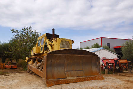 Gialova, Greece - Oct 9, 2013: Caterpillar Motor Grader shown at a garage backyard in countrysideのeditorial素材