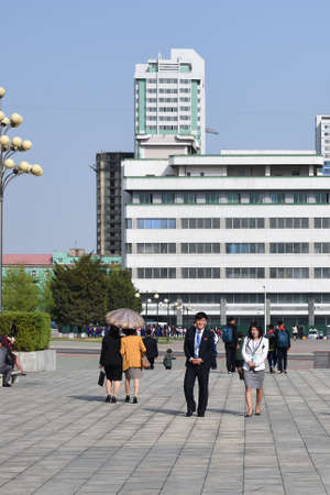 Pyongyang, North Korea - April 29, 2019: People rush about their business in a city street not far...