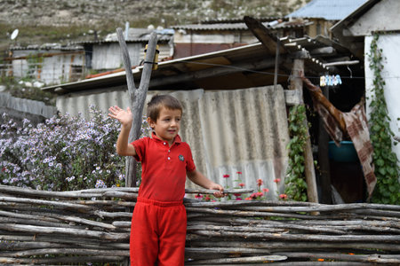 Chechnya, Russia - Sept 12, 2021: Little Chechen boy shown at his house with a welcome hand gestureのeditorial素材