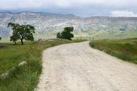 Dirt road in the countryside of Dagestan. Caucasus mountains on background. Russiaの写真素材