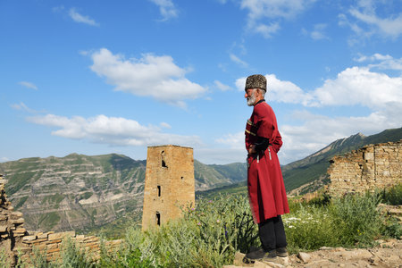 Dagestan, Russia - 21 July, 2022: Local man in national tradition dress stays against battle tower...