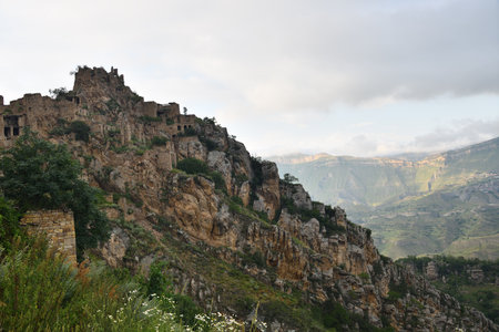 Ancient village Gamsutl on rock on background of mountains. Amazing settlement of rock houses on top of mountain. Attraction of Dagestan - village of ghost in mountainsのeditorial素材
