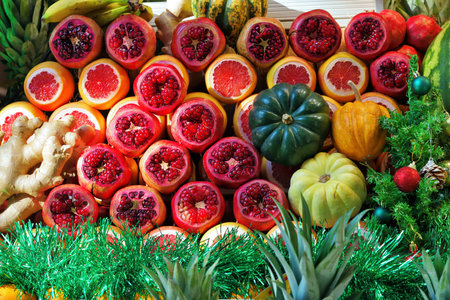 Street display case with fruits and vegetables decorated with Christmas symbols with a spruce tree and Christmas tree decorations and tinsel. Sale of freshly squeezed juicesの写真素材