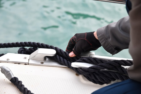 Man hands and yacht rope cleat, yacht detail. Yachtingの写真素材
