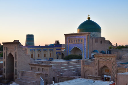 View to Mausoleum of Pahlavon Mahmoud.. Cityscape in Ichan Kala at sunset time, ancient inner town of the old city Khiva in Khorezm region, Uzbekistanの写真素材