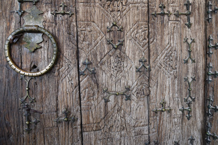 Beautiful ancient carved wooden door with massive brass handle. Khiva. Uzbekistanの写真素材