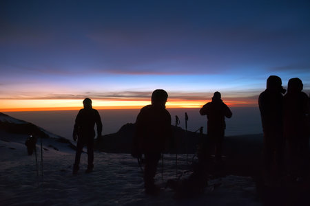 Silhouettes of climbers during night climb and sunrise on Kilimanjaro, Tanzania, Africa. Sunrise over Uhuru peak, top of Kilimanjaro (5.895 m) highest mountain in Africa.の写真素材