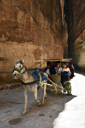 Petra, Jordan - Apr 2, 2015: Unidentified people in a horse carriage in a gorge. Siq canyon in Petra, Jordan. Petra is one of the New Seven Wonders of the World.のeditorial素材