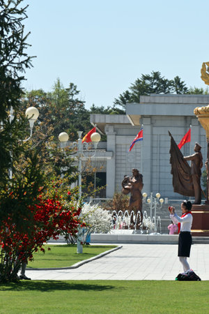 Pyongyang, North Korea - May 2, 2019: Pioneer girl takes a mobile photo in the territory Kumsusan...