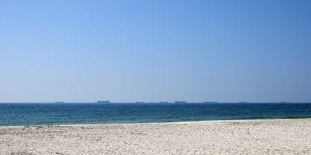 Silhouette of cargo ships line on horizont. Arabian sea coastline. Omanの写真素材