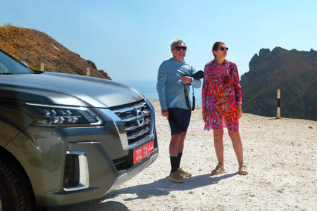 Salalah, Oman - Feb 02, 2026: Couple of tourists, man and woman in Dhofar mountains near Salalah, Arabian sea on background. Oman. Jabal Shaat view point. Governorate of Dhofarのeditorial素材