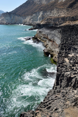 Blow Beach near Mughsail in Oman. The scenery is breathtaking rugged mountains on one side and the powerful Arabian Sea on the otherin the Governorate of Dhofarの写真素材