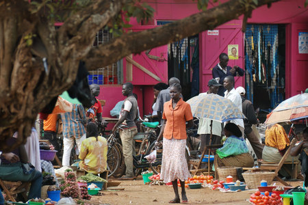 Fort Portal, Uganda - Aug 27, 2010: Local people make a purchase on the street market. Nearly 40% of slum dwellers have a monthly income of just 2,500 shillings less than a dollarのeditorial素材