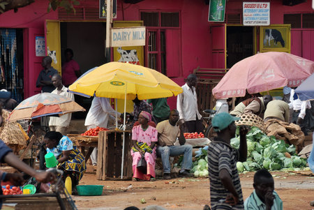 Fort Portal, Uganda - Aug 28, 2010: Local people make a purchase on the street market. Nearly 40% of slum dwellers have a monthly income of just 2,500 shillings less than a dollarのeditorial素材