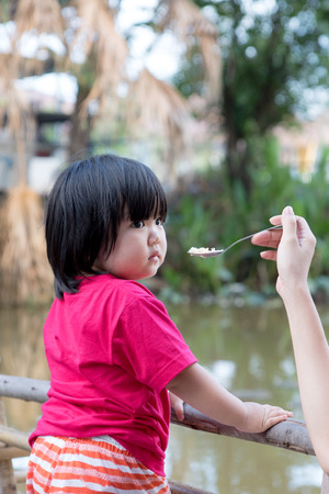 Children Girl Naive Fed Rice at Canalの写真素材