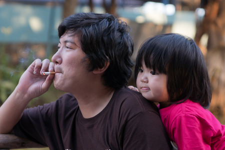 He smokes in front of daughter is badの写真素材