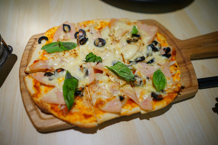 Pizza with basil leaf and ham cheeseの写真素材