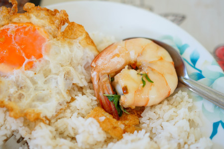 eating fried egg and shrimp with basilの写真素材