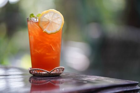 ice tea glass with mint and lemon on wooden tableの写真素材