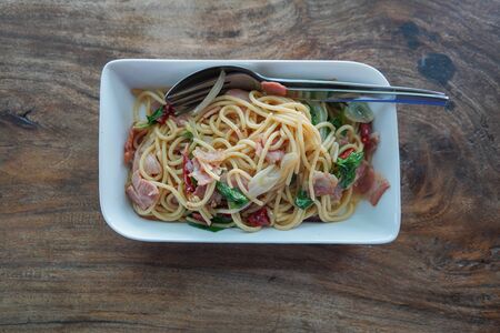 Stock Photo - Spaghetti spicy bacon with hot basil on wooden tableの写真素材