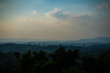 Mountains range in fog with forest background on sunsetの写真素材