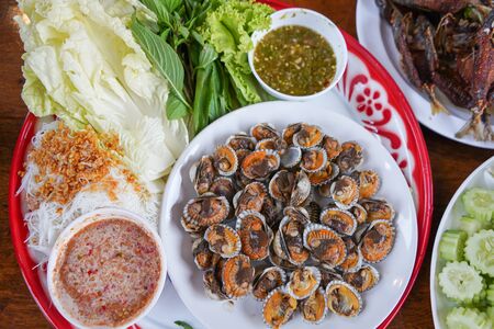 Savoury Leaf Wraps Boiled Cockle with spicy sauce and rice noodlesの写真素材