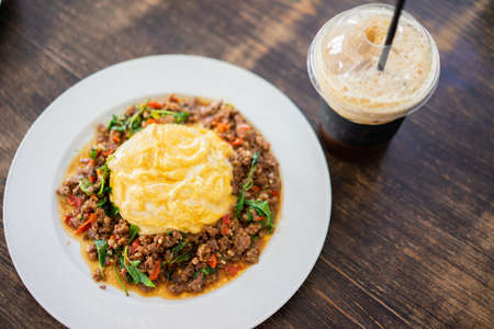Beef with Basil top on rice and Scrambled eggs serve with Iced Americanoの写真素材