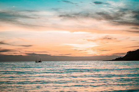 Fishing boat on sea during colorful sunset