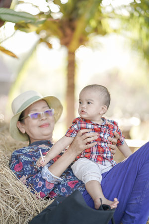 A cute baby boy with his blured grandmom relex timeon straw.の写真素材