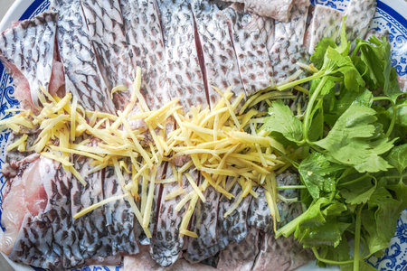 Tilapia fish fillet prepare to dip with ginger slice and celery.の写真素材