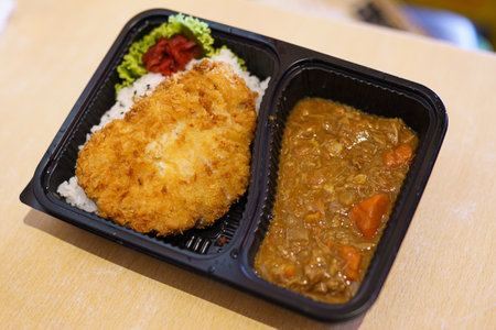 Pork cutlet curry rice (Tonkatsu curry rice, Katsu Kare), Popular Japanese food. Japanese fried crispy pork cutlet (Tonkatsu) served with curry, scrambled eggs and Japanese rice in black plastic box.の写真素材