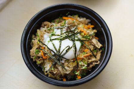 Gyudon is one of the Japanese comfort food in which sliced beef and onion simmered in sweet and salty sauce made of soy sauce and sugar are topped on warm rice. boxed don.の写真素材