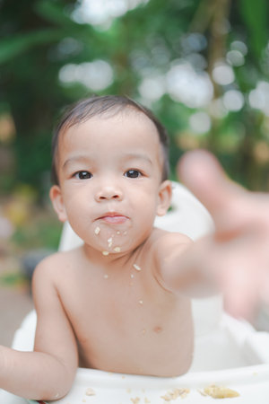 A Little baby eating dinner and making a mess.の写真素材