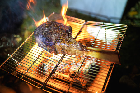 Beef Tomahawk steak on the grill with smoke and flames selective focus.の写真素材