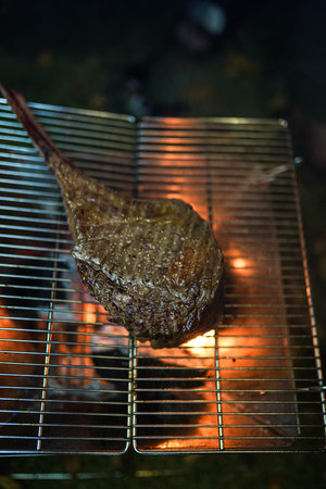 Beef Tomahawk steak on the grill with smoke and flames selective focus.の写真素材