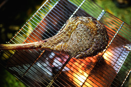 Beef Tomahawk steak on the grill with smoke and flames.の写真素材