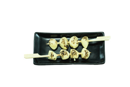 Grilled garlic on black plate isolated on white background with clipping pathの写真素材