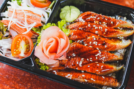 Close up Bento set, Japanese meal in a Box - grilled unagi or eel with rice, salad.の写真素材
