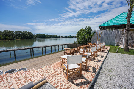 Outdoor bar of cafe wooden tables and chairs decoration near river.の写真素材