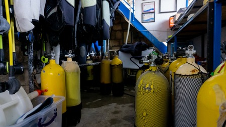 Scuba diving gear storage with many oxygen yellow tanks in an old storeの写真素材