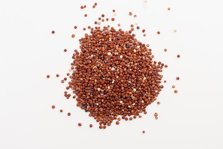isolated red quinoa seeds spilled on white backgroundの写真素材